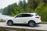 Picture of a driving 2019 Acura RDX SH-AWD in White Diamond Pearl from a rear left three-quarter perspective