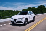 Picture of a driving 2018 Alfa Romeo Stelvio Ti Lusso AWD in Trofeo White Tri-Coat from a front left three-quarter perspective