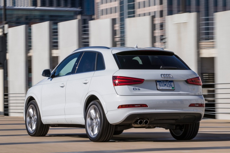 Picture of a driving 2015 Audi Q3 2.0T in Cortina White from a rear left three-quarter perspective