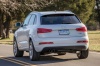Picture of a driving 2015 Audi Q3 2.0T in Cortina White from a rear left perspective