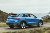 Picture of a driving 2019 Audi Q3 45 quattro in Turbo Blue from a rear right three-quarter perspective