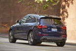Picture of a driving 2015 Audi SQ5 Quattro in Scuba Blue Metallic from a rear left perspective