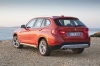 Picture of a 2014 BMW X1 in Valencia Orange Metallic from a rear left perspective