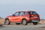 Picture of a 2015 BMW X1 in Valencia Orange Metallic from a rear left three-quarter perspective