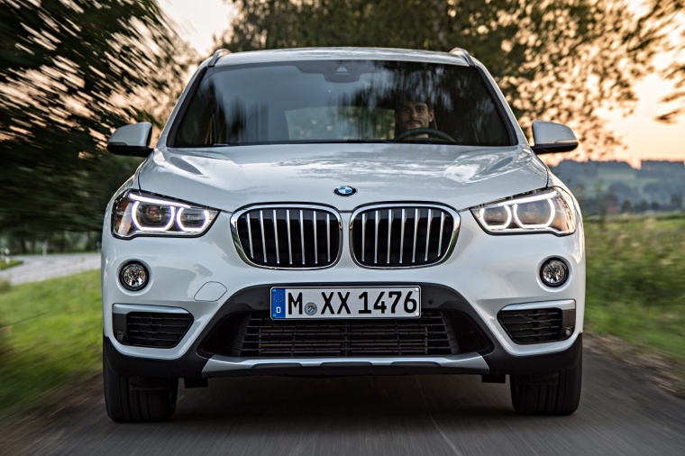 Picture of a driving 2016 BMW X1 xDrive28i in Alpine White from a frontal perspective