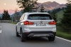 Picture of a driving 2016 BMW X1 xDrive28i in Alpine White from a rear perspective