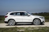 Picture of a driving 2016 BMW X1 xDrive28i in Alpine White from a side perspective