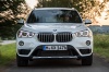 Picture of a driving 2018 BMW X1 xDrive28i in Alpine White from a frontal perspective