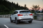 Picture of a driving 2019 BMW X1 xDrive28i in Alpine White from a rear left perspective