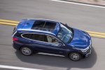 Picture of a driving 2019 BMW X1 xDrive28i in Mediterranean Blue from a front right three-quarter top perspective