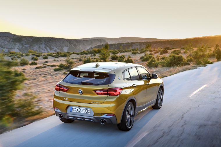 Picture of a driving 2018 BMW X2 in Galvanic Gold Metallic from a rear right perspective