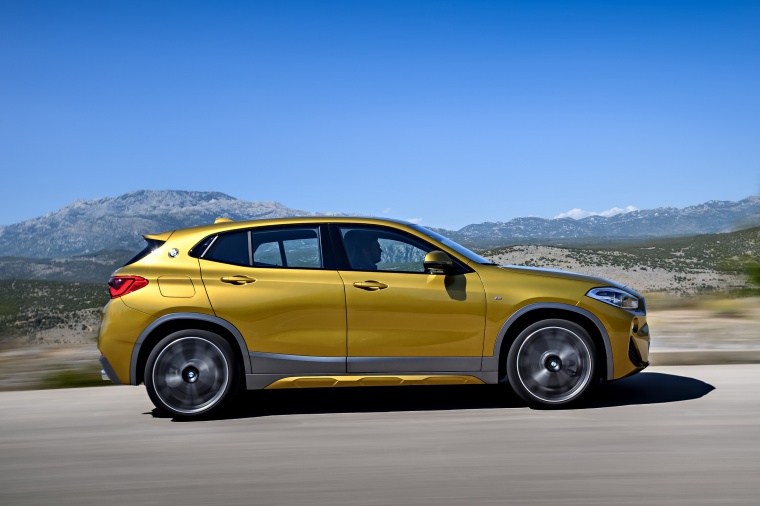 Picture of a driving 2018 BMW X2 in Galvanic Gold Metallic from a right side perspective