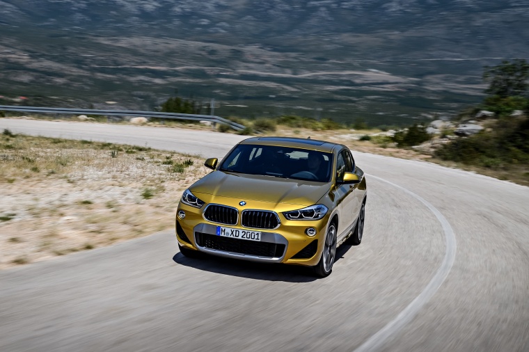 Picture of a driving 2018 BMW X2 in Galvanic Gold Metallic from a front left perspective