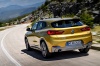 Picture of a driving 2018 BMW X2 in Galvanic Gold Metallic from a rear left perspective