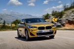 Picture of a driving 2018 BMW X2 in Galvanic Gold Metallic from a front right perspective
