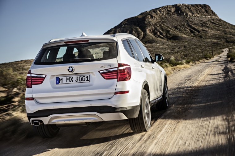 Picture of a driving 2015 BMW X3 in Mineral White Metallic from a rear right perspective