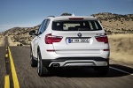 Picture of a driving 2015 BMW X3 in Mineral White Metallic from a rear perspective