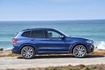 Picture of a driving 2018 BMW X3 M40i in Phytonic Blue Metallic from a right side perspective