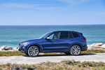 Picture of a driving 2018 BMW X3 M40i in Phytonic Blue Metallic from a left side perspective