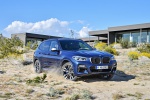 Picture of a driving 2019 BMW X3 M40i in Phytonic Blue Metallic from a front right three-quarter perspective