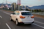 Picture of a driving 2017 BMW X5 xDrive50i in Alpine White from a rear left perspective