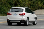 Picture of a driving 2017 BMW X5 xDrive50i in Alpine White from a rear right perspective