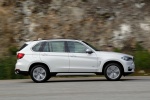 Picture of a driving 2017 BMW X5 xDrive50i in Alpine White from a right side perspective