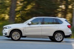 Picture of a driving 2017 BMW X5 xDrive50i in Alpine White from a left side perspective