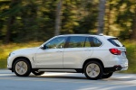 Picture of a driving 2017 BMW X5 xDrive50i in Alpine White from a rear left three-quarter perspective
