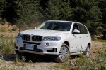 Picture of a driving 2017 BMW X5 xDrive50i in Alpine White from a front left three-quarter perspective