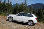 Picture of a driving 2017 BMW X5 xDrive50i in Alpine White from a side perspective