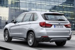 Picture of a driving 2017 BMW X5 xDrive40e in Glacier Silver Metallic from a rear left three-quarter perspective