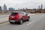 Picture of a driving 2016 Buick Encore in Winterberry Red Metallic from a rear right three-quarter perspective