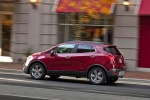 Picture of a driving 2016 Buick Encore in Winterberry Red Metallic from a side perspective