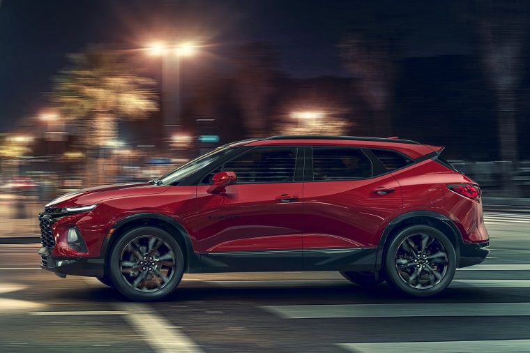 Picture of a driving 2019 Chevrolet Blazer RS AWD in Red Hot from a side perspective