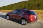Picture of a driving 2015 Chevrolet Equinox LTZ in Crystal Red Tintcoat from a rear left three-quarter perspective