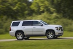 Picture of a driving 2015 Chevrolet Tahoe in Silver Ice Metallic from a side perspective