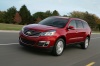 Picture of a driving 2016 Chevrolet Traverse LTZ AWD in Siren Red Tintcoat from a front left three-quarter perspective