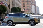 Picture of a driving 2014 Ford Escape Titanium 4WD in Ginger Ale Metallic from a right side perspective