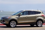 Picture of a driving 2014 Ford Escape Titanium 4WD in Ginger Ale Metallic from a left side perspective