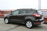 Picture of a driving 2014 Ford Escape in Tuxedo Black from a rear left three-quarter perspective