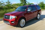 Picture of a driving 2015 Ford Expedition Platinum in Ruby Red Metallic Tinted Clearcoat from a front left perspective