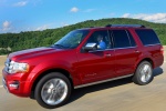 Picture of a driving 2015 Ford Expedition Platinum in Ruby Red Metallic Tinted Clearcoat from a front left three-quarter perspective