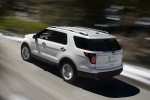 Picture of a driving 2014 Ford Explorer Limited 4WD in White from a rear left three-quarter perspective