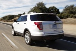Picture of a driving 2014 Ford Explorer Limited 4WD in White from a rear left perspective