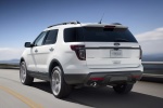 Picture of a driving 2014 Ford Explorer Sport 4WD in White Platinum Metallic Tri-Coat from a rear left perspective