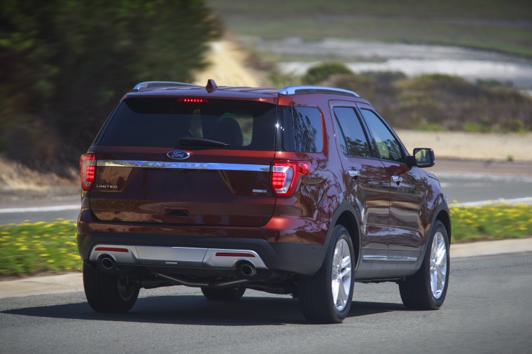 Picture of a driving 2016 Ford Explorer Limited 4WD in Bronze Fire Metallic Tinted Clearcoat from a rear right perspective