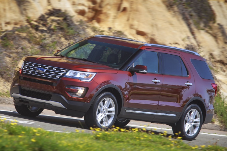 Picture of a driving 2016 Ford Explorer Limited 4WD in Bronze Fire Metallic Tinted Clearcoat from a front left perspective