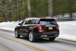 Picture of a driving 2020 Ford Explorer Platinum V6 EcoBoost 4WD in Rich Copper Metallic Tinted Clearcoat from a rear left perspective