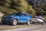 Picture of a driving 2020 Ford Explorer Hybrid Limited 4WD's with boat trailer in Atlas Blue Metallic from a front left perspective